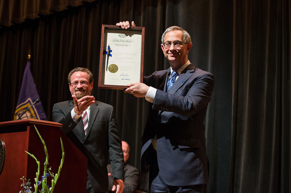 Assemblymember Harry Bronson presents University of Rochester president Joel Seligman with a copy of the legislation that enabled the University of Rochester Peace Officer program to proceed.