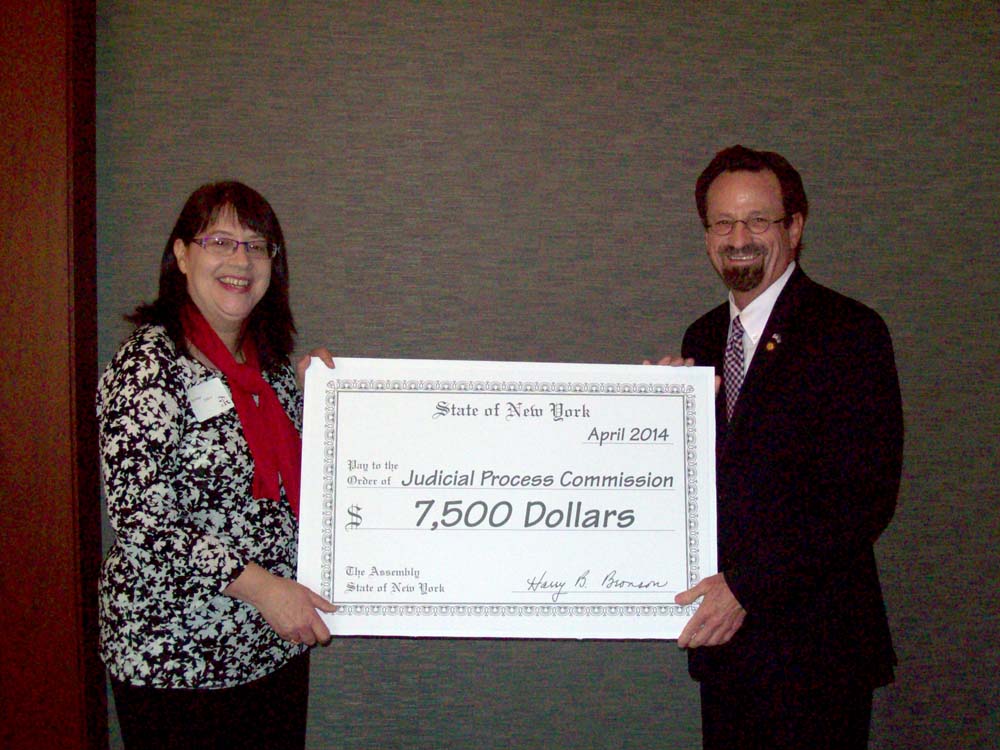 Assemblymember Bronson presents a check to Sue Porter from the Judicial Process Commission for $7,000. The money was secured by Bronson through the Edward Byrne Memorial Justice Assistance Grant Progr